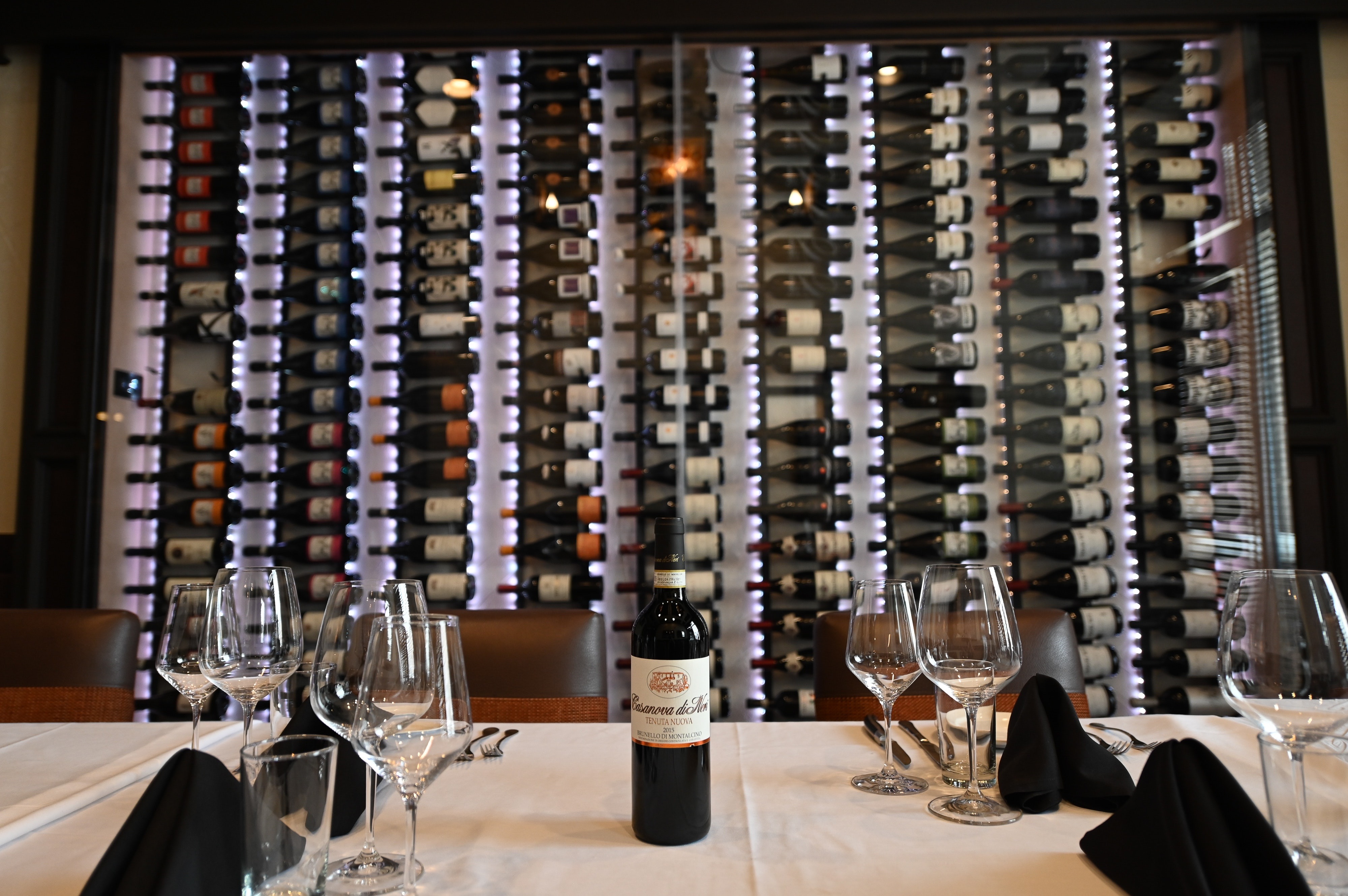 a bottle of wine glasses on a table
