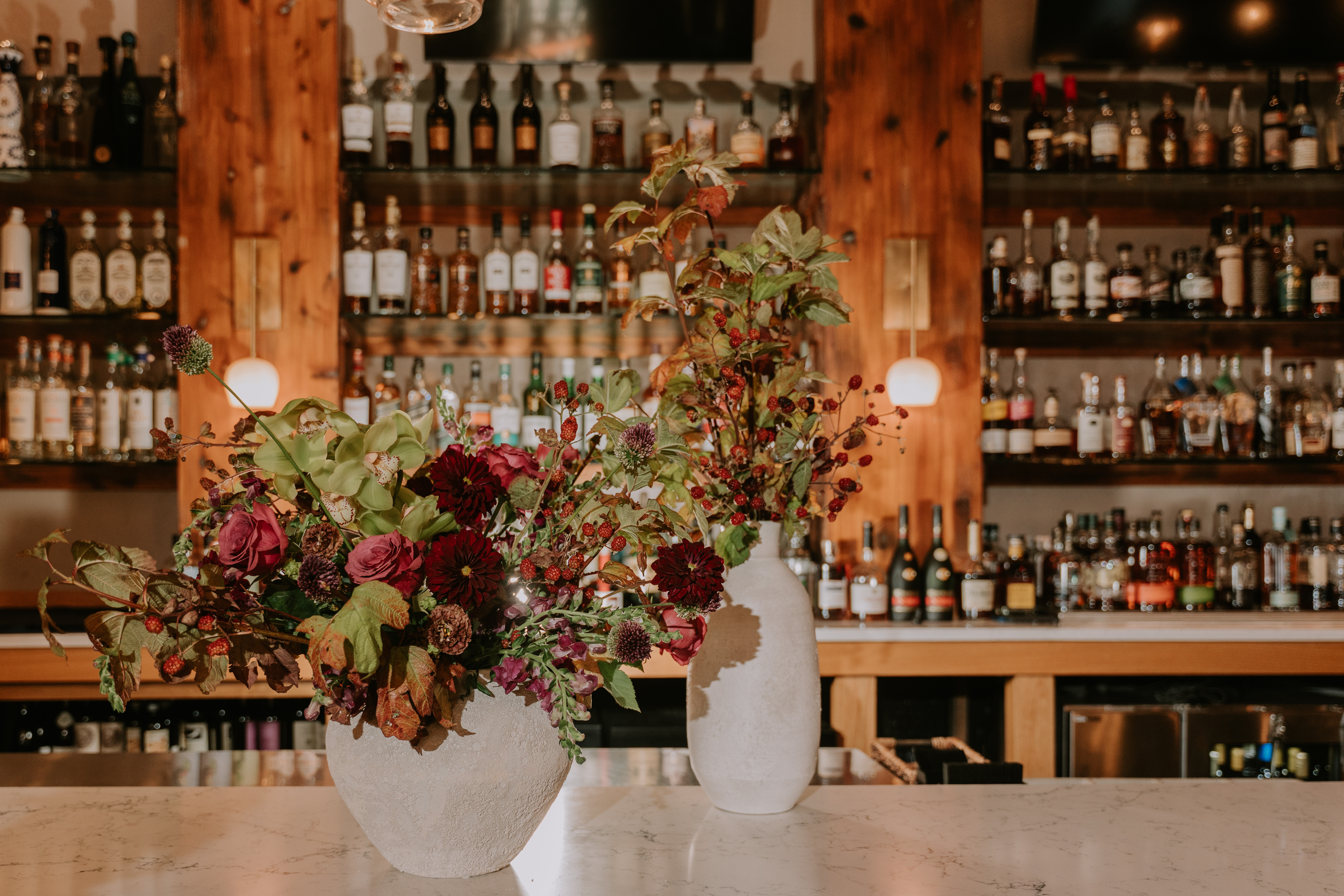 a bottle of wine and a vase of flowers on a table