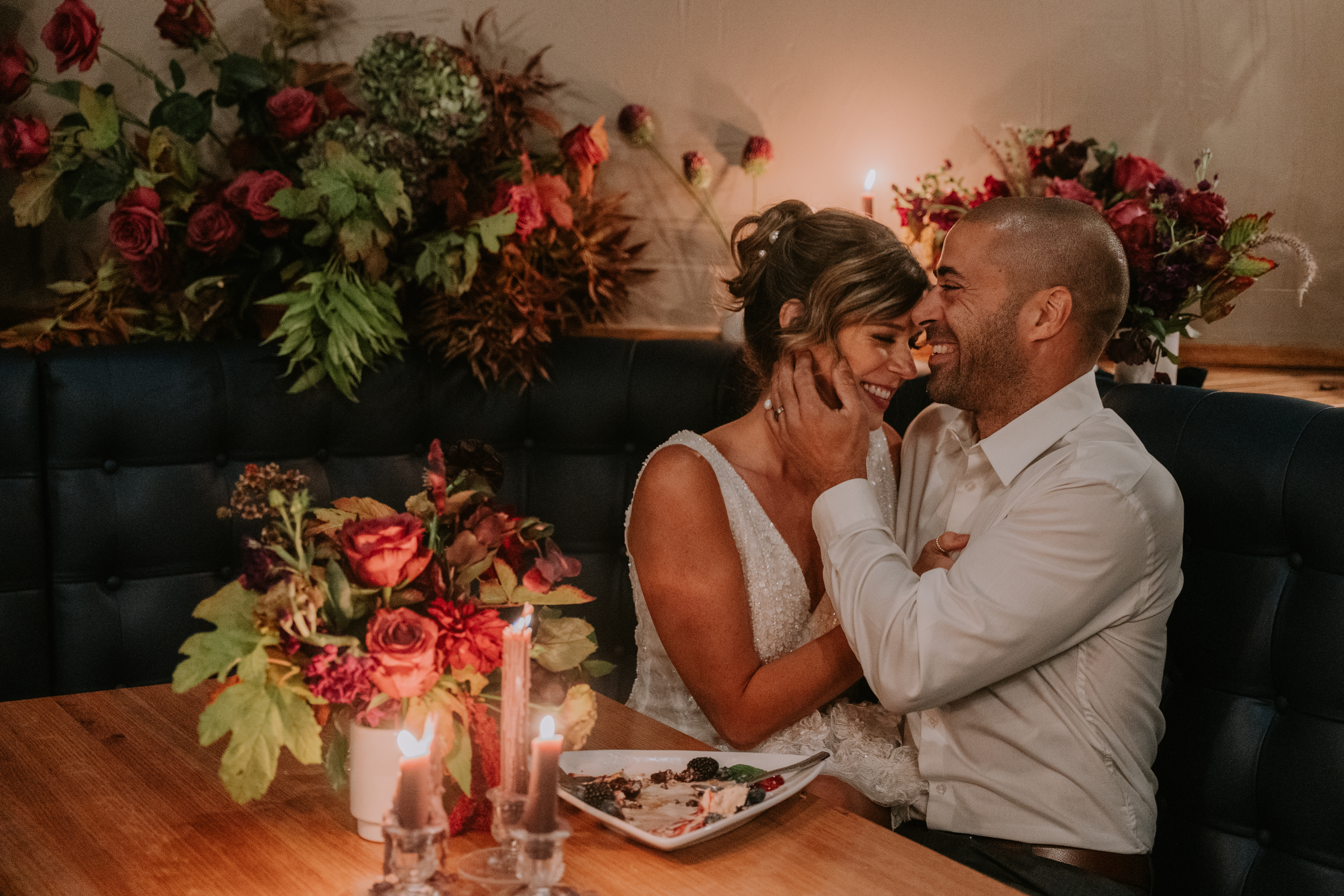 a person sitting at a table with a vase of flowers