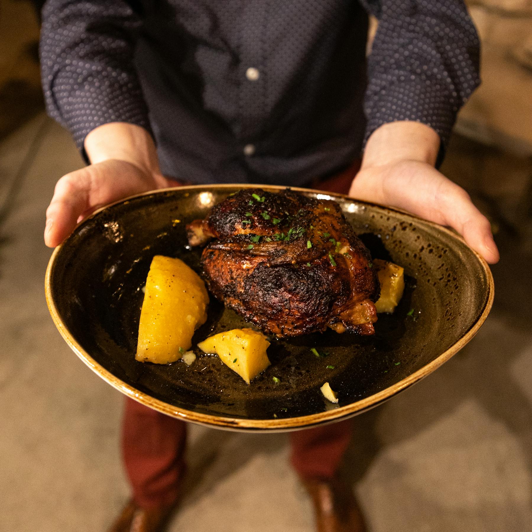 a person holding a pan of food