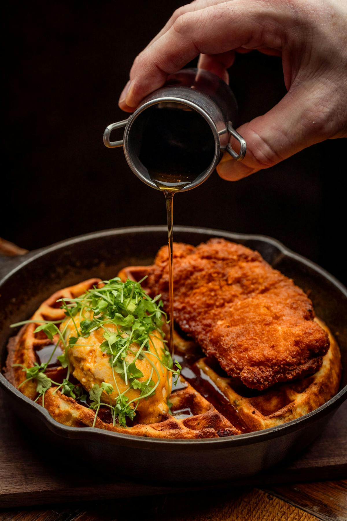 a close up of a person holding a pan of food on a table