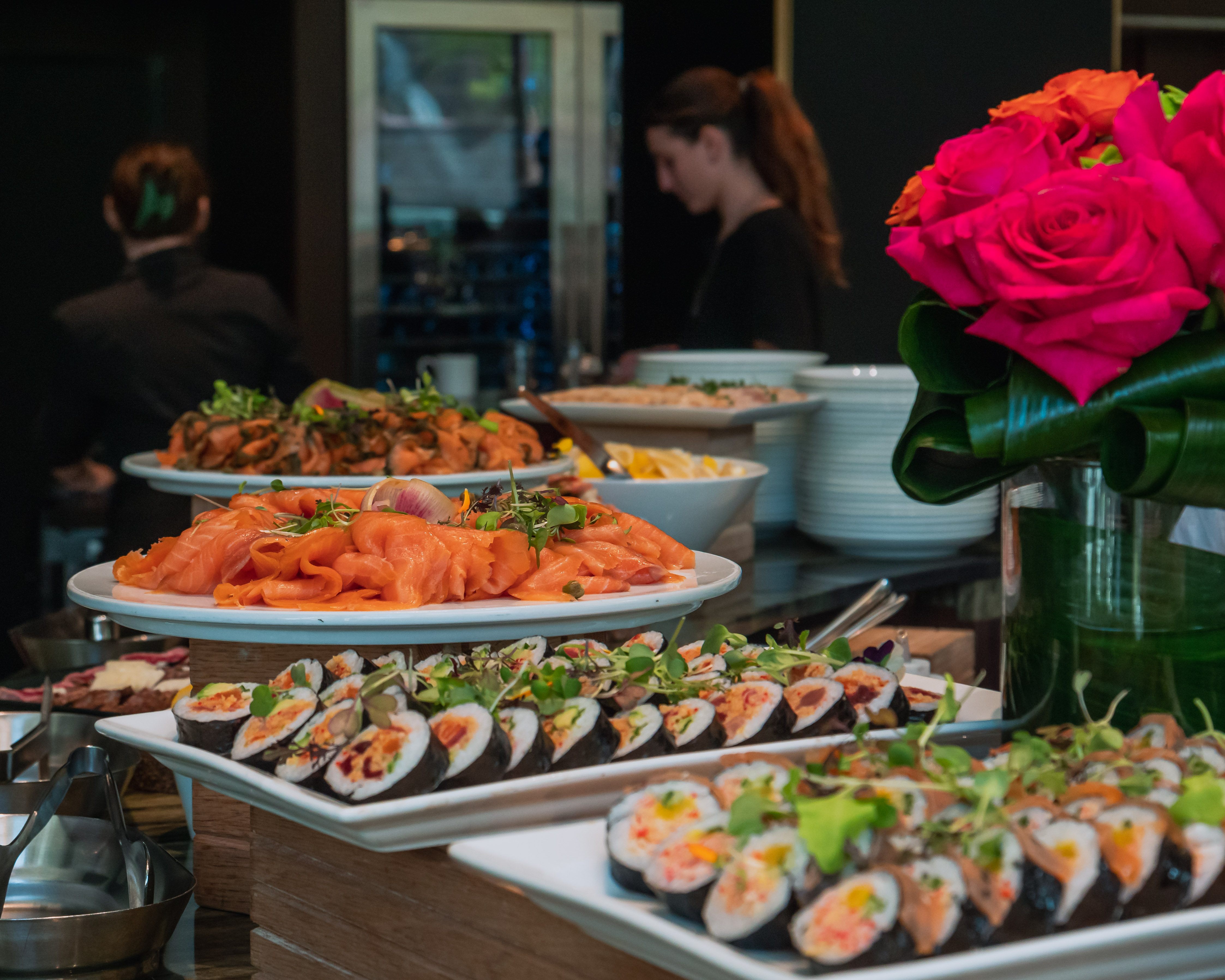 a group of people sitting at a table with many different types of food