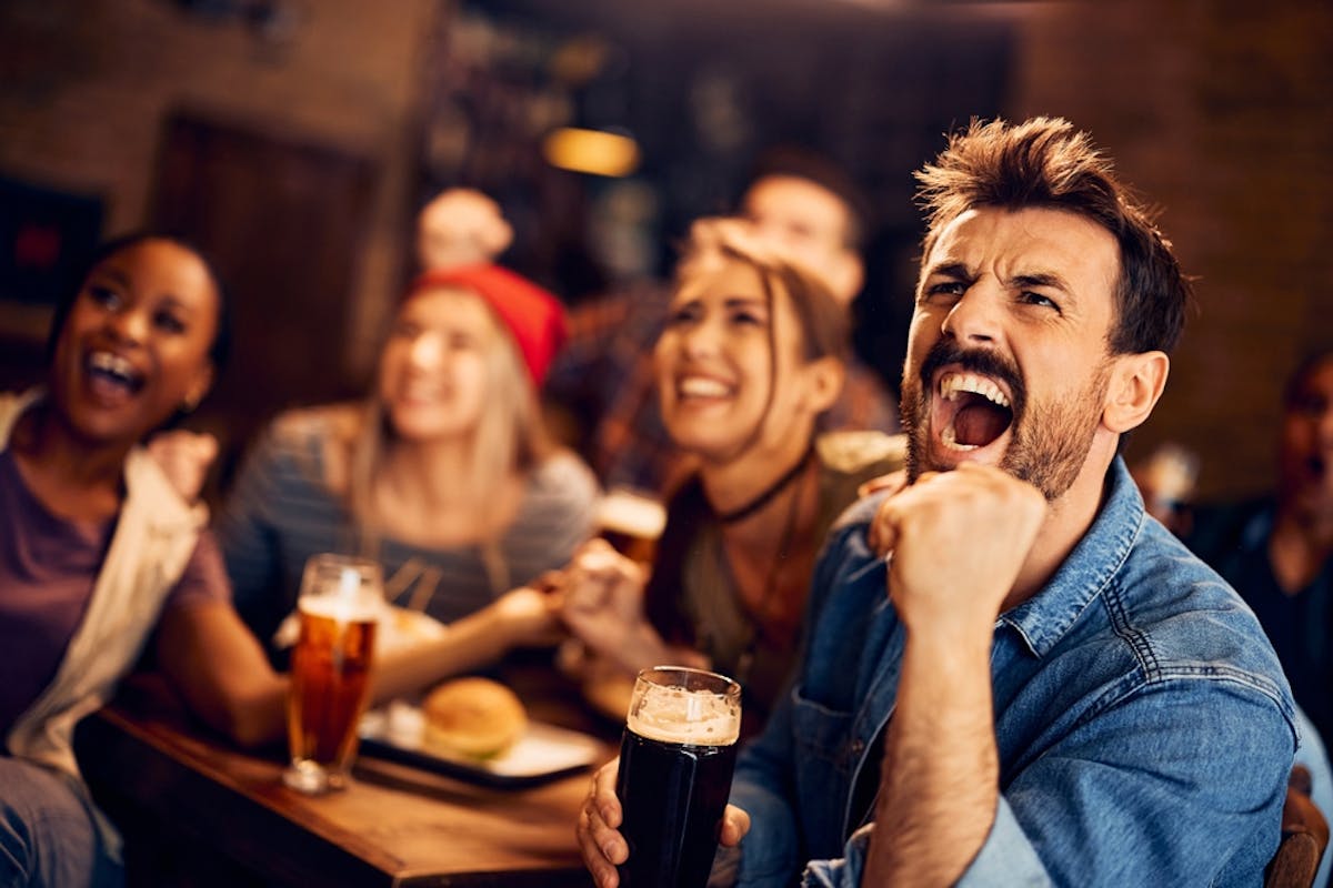 man cheering with women and a beer
