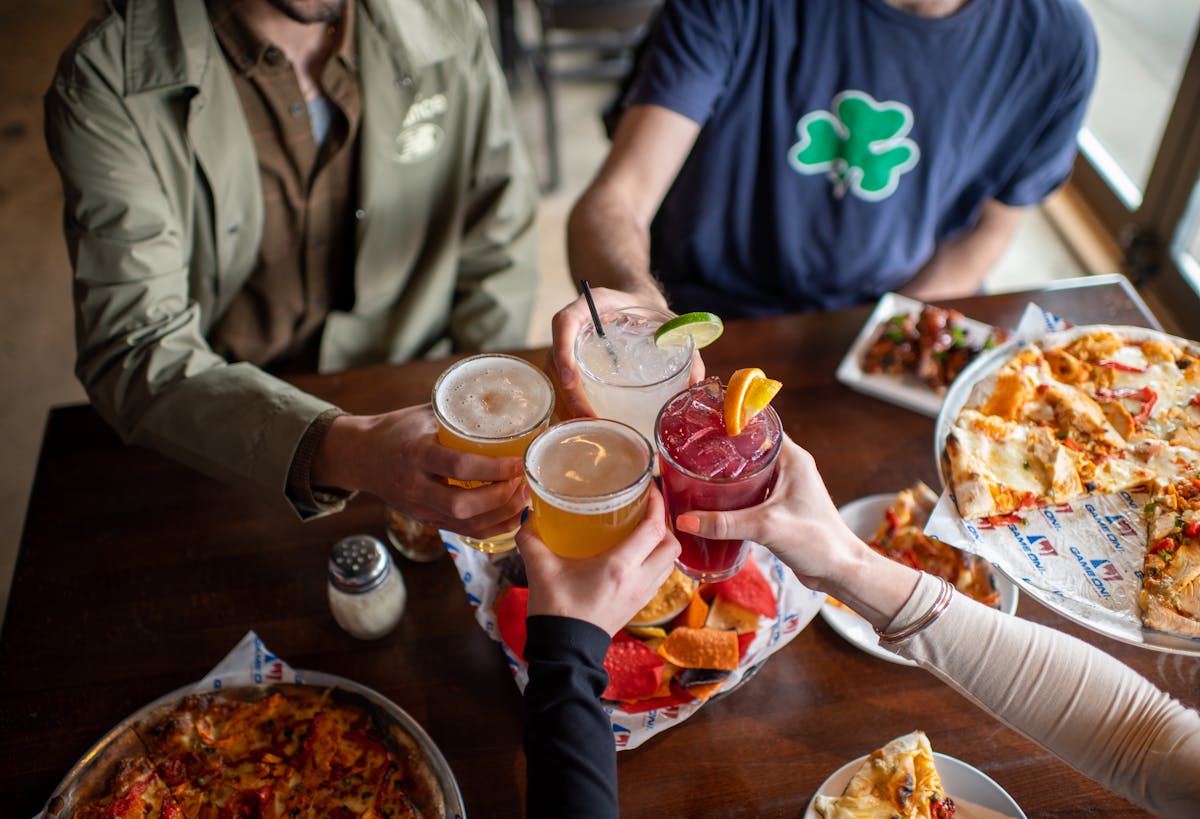 a group of people sitting at a table with plates of food