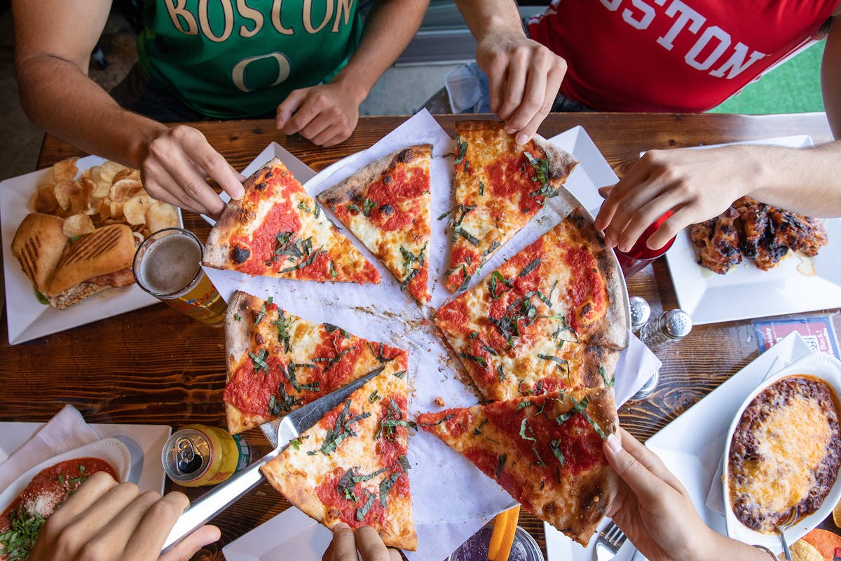 a group of people sitting at a table with a plate of food