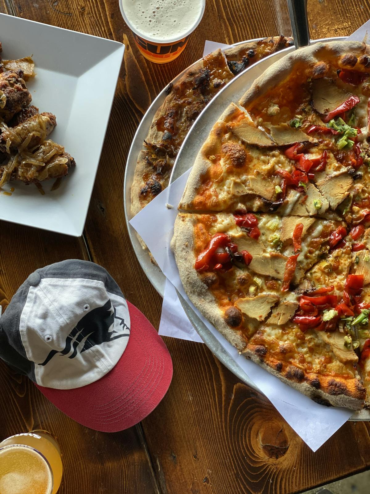 a pizza sitting on top of a plate of food on a table