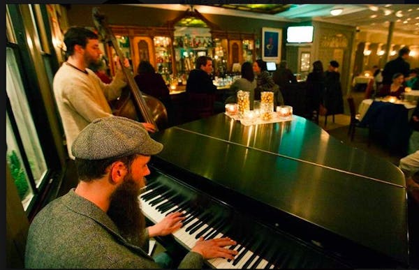 a group of people standing in front of a piano