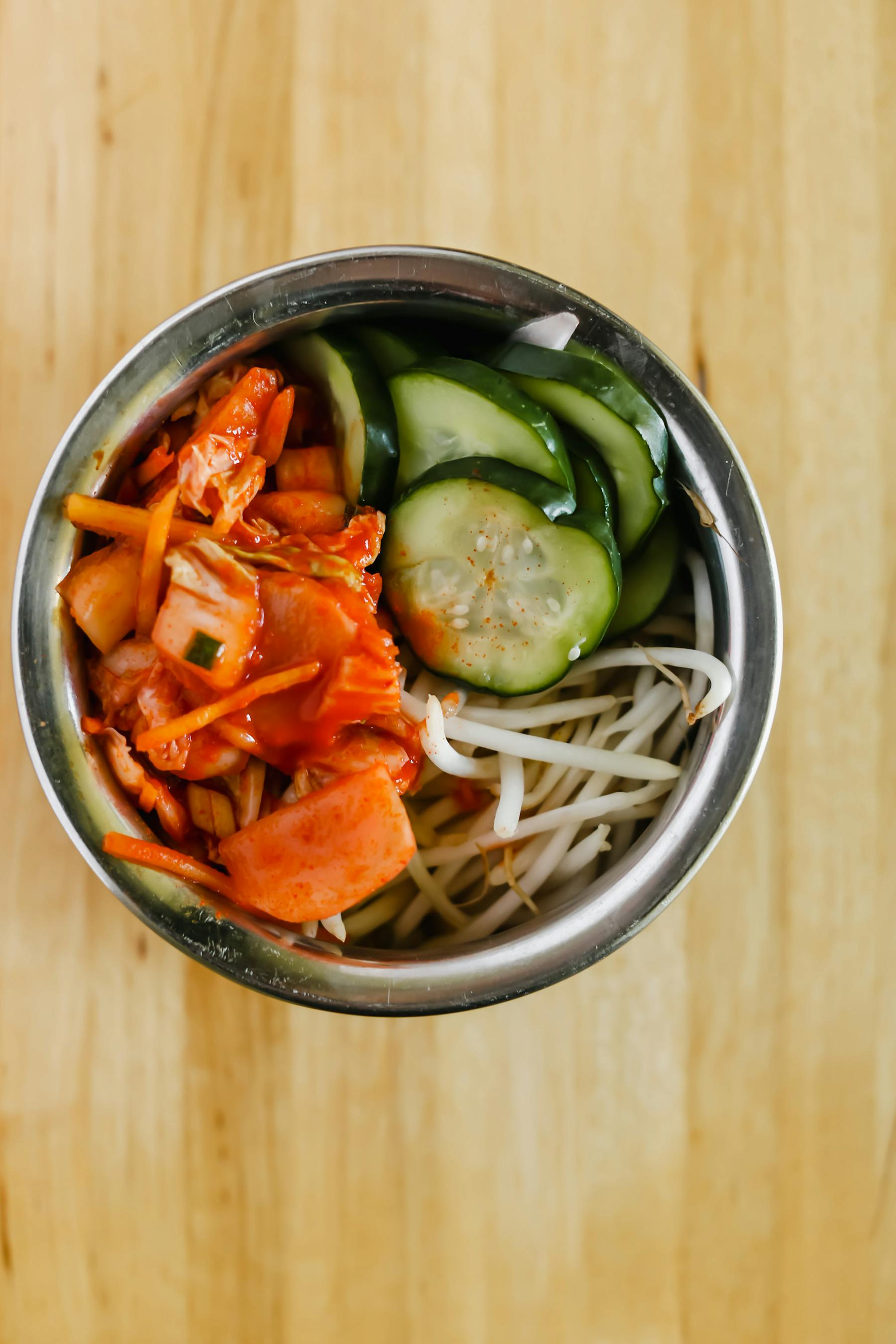 a bowl of vegetables on a wooden table