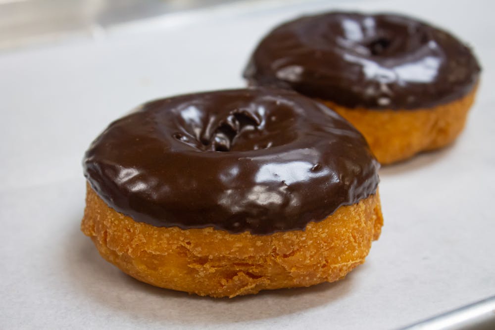 a close up of a chocolate doughnut on a plate