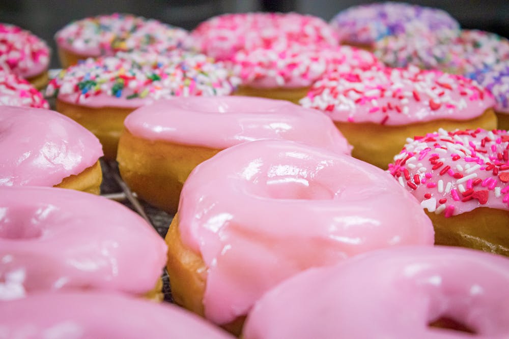 a close up of a pink box filled with donuts
