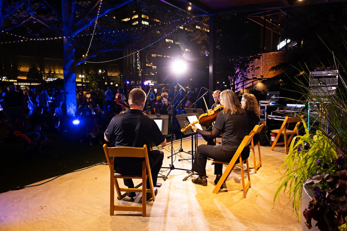 a group of people playing instruments and performing on a stage