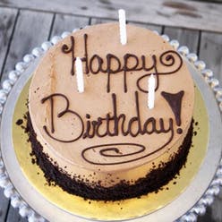 a sign in front of a birthday cake