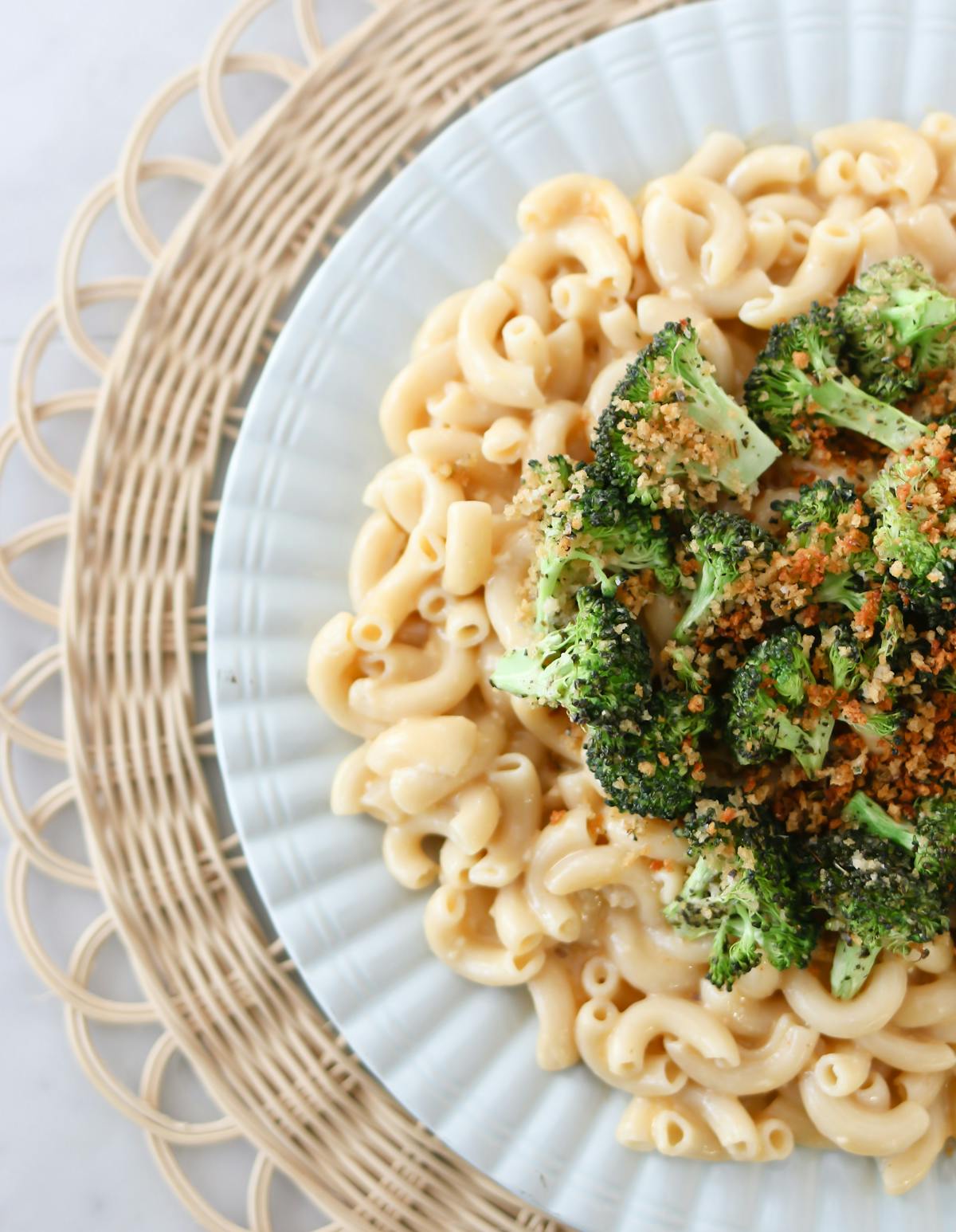 a bowl filled with pasta and broccoli on a plate