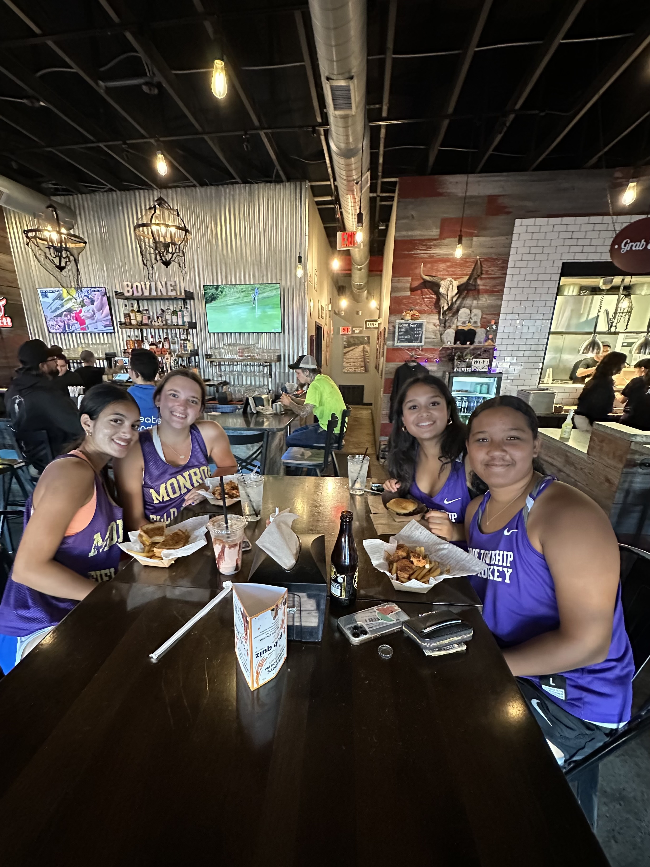 high school sports team sitting at a table in a restaurant