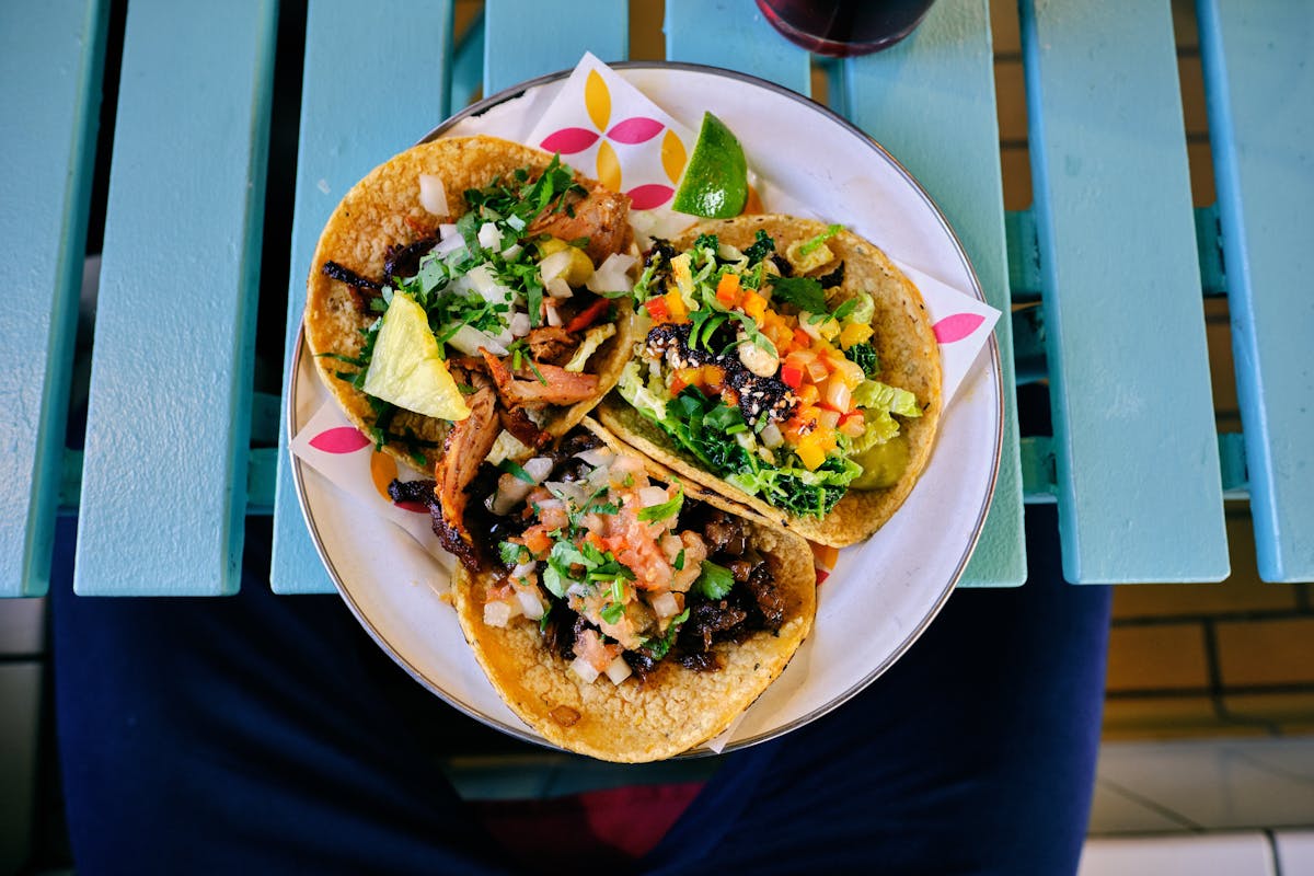 three tacos topped with greens