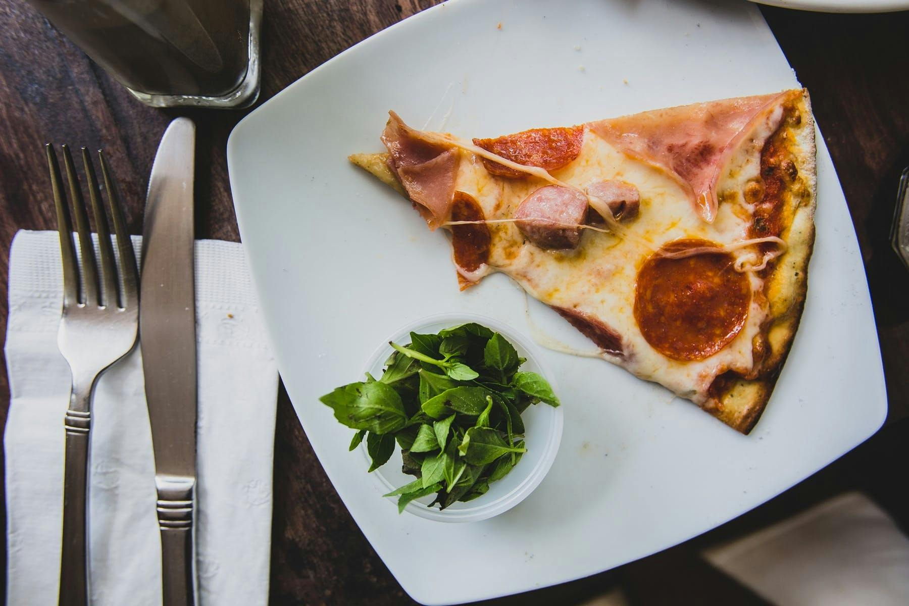 a plate of food with a slice of pizza