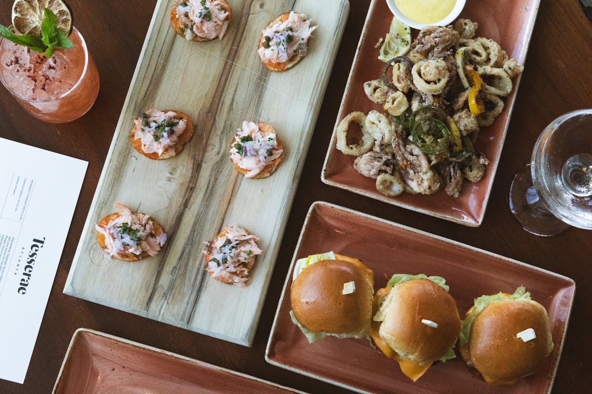 plates of calamari, sliders, and arepas to share on a table at tesserae