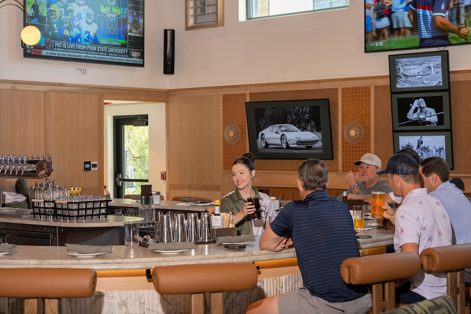 Crowd watching live sports at 1983, a South Tampa sports bar with wall-to-wall TVs, game-day energy, and a full bar built for fans.