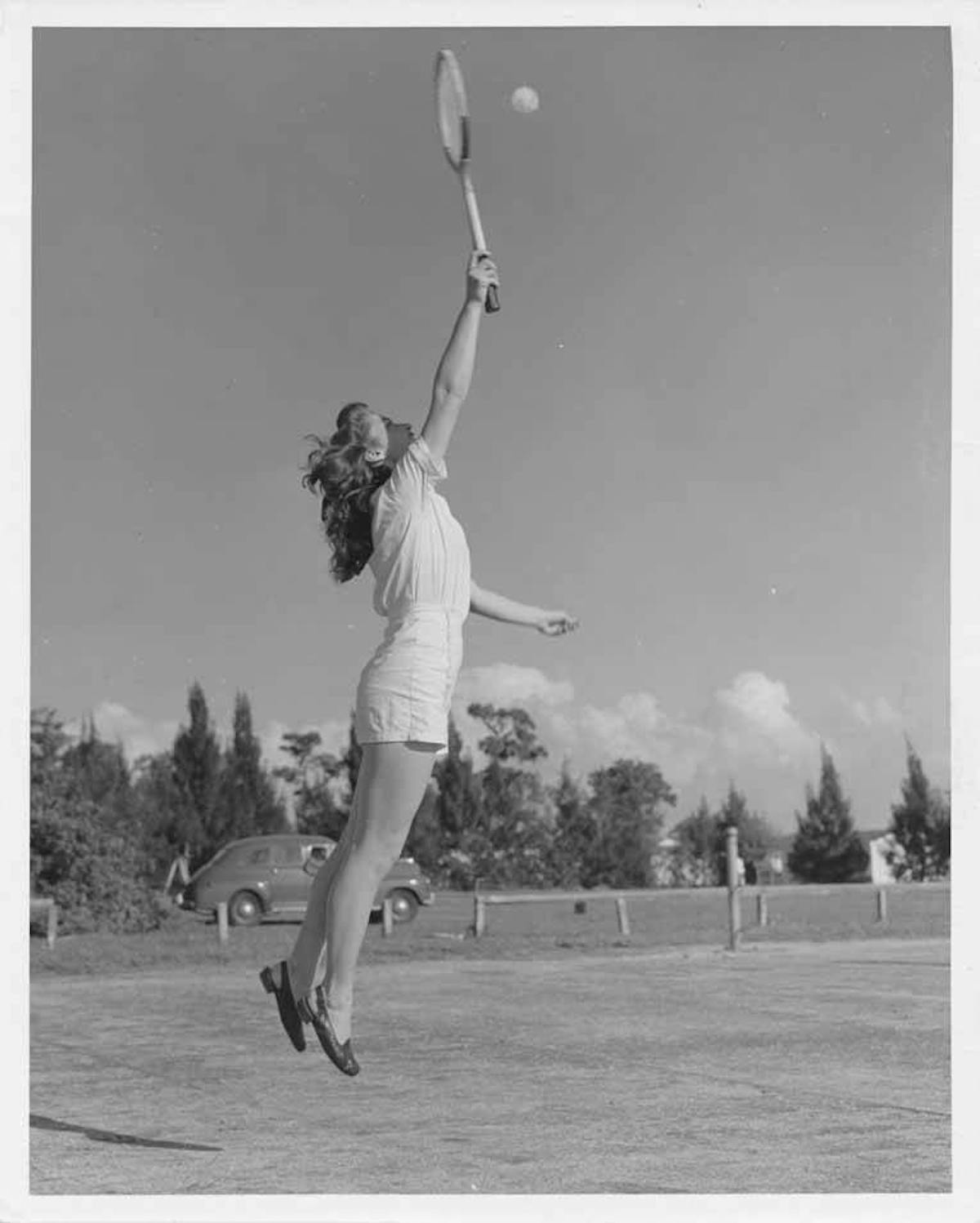 a woman jumping into the air to catch a frisbee