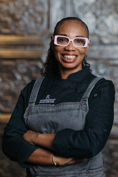 a person wearing glasses and smiling at the camera