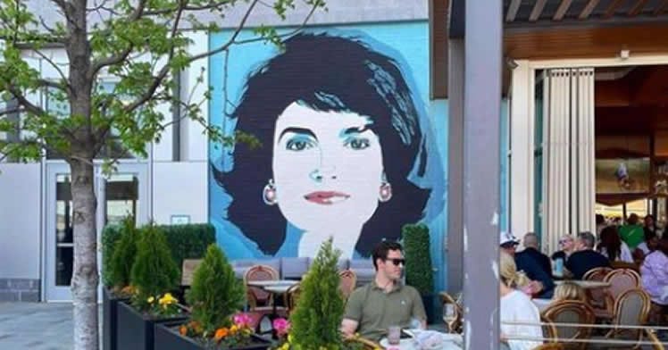 a group of people sitting at a table in front of a building