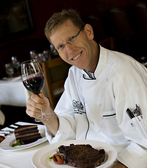 a man sitting at a table with a plate of food