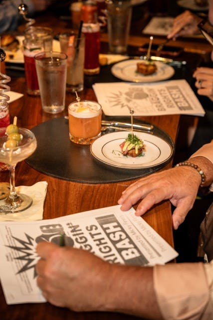 a man sitting at a table with wine glasses