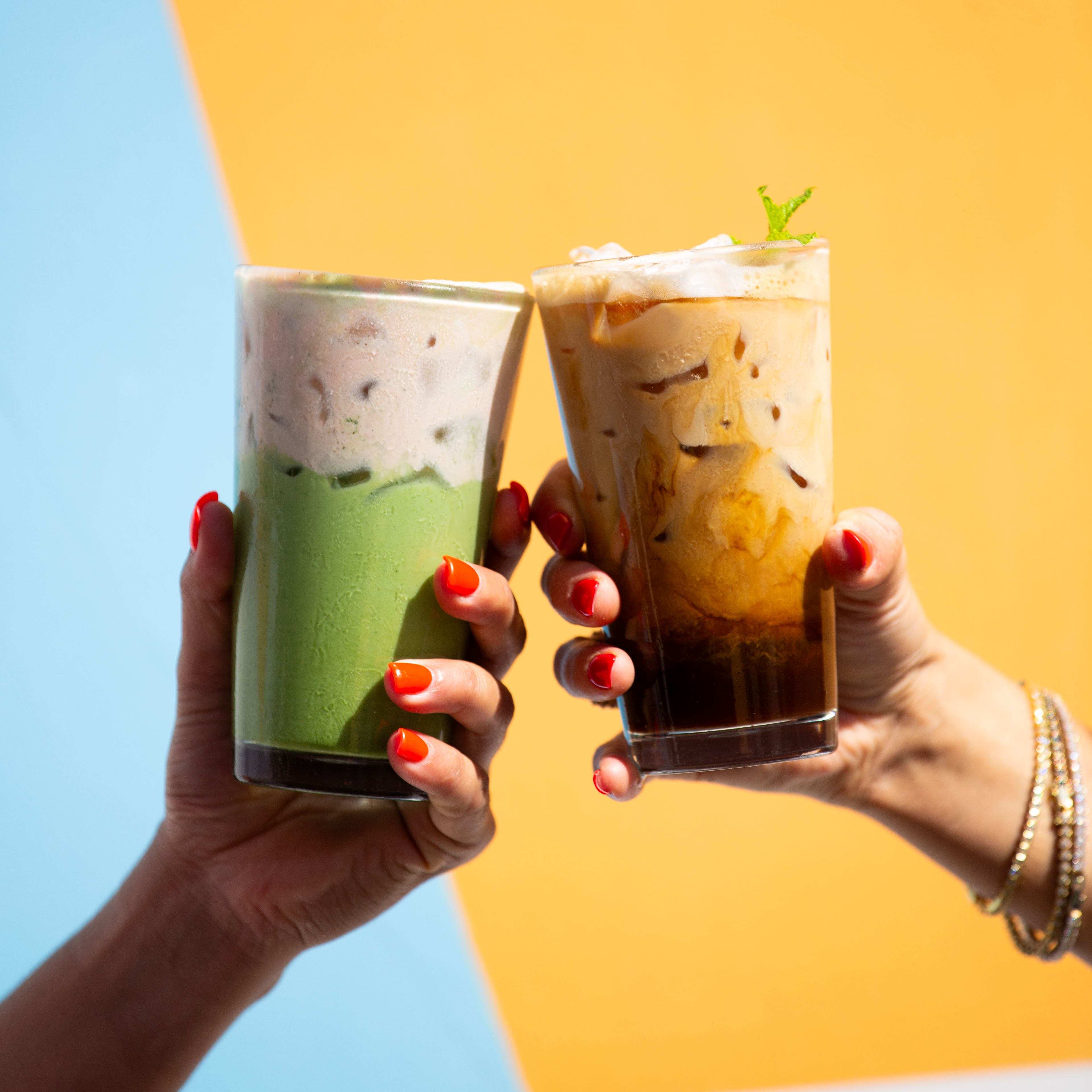 a pair of hands holding up drinks