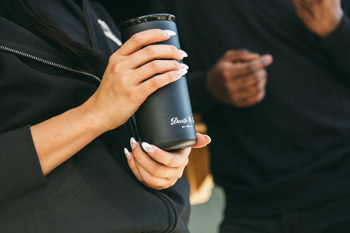 a woman holding a tumbler from death and co