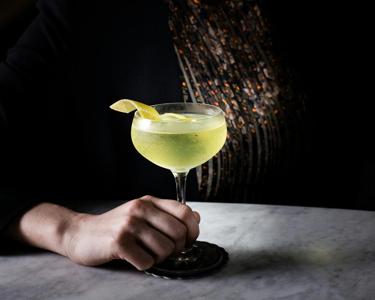 a hand holding a cocktail glass