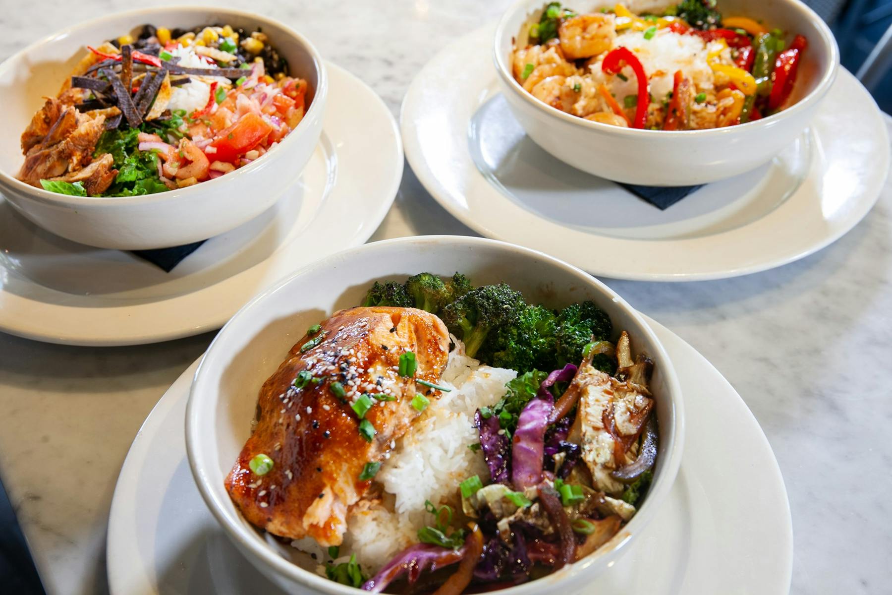 3 bowls of food on their own plates on the table