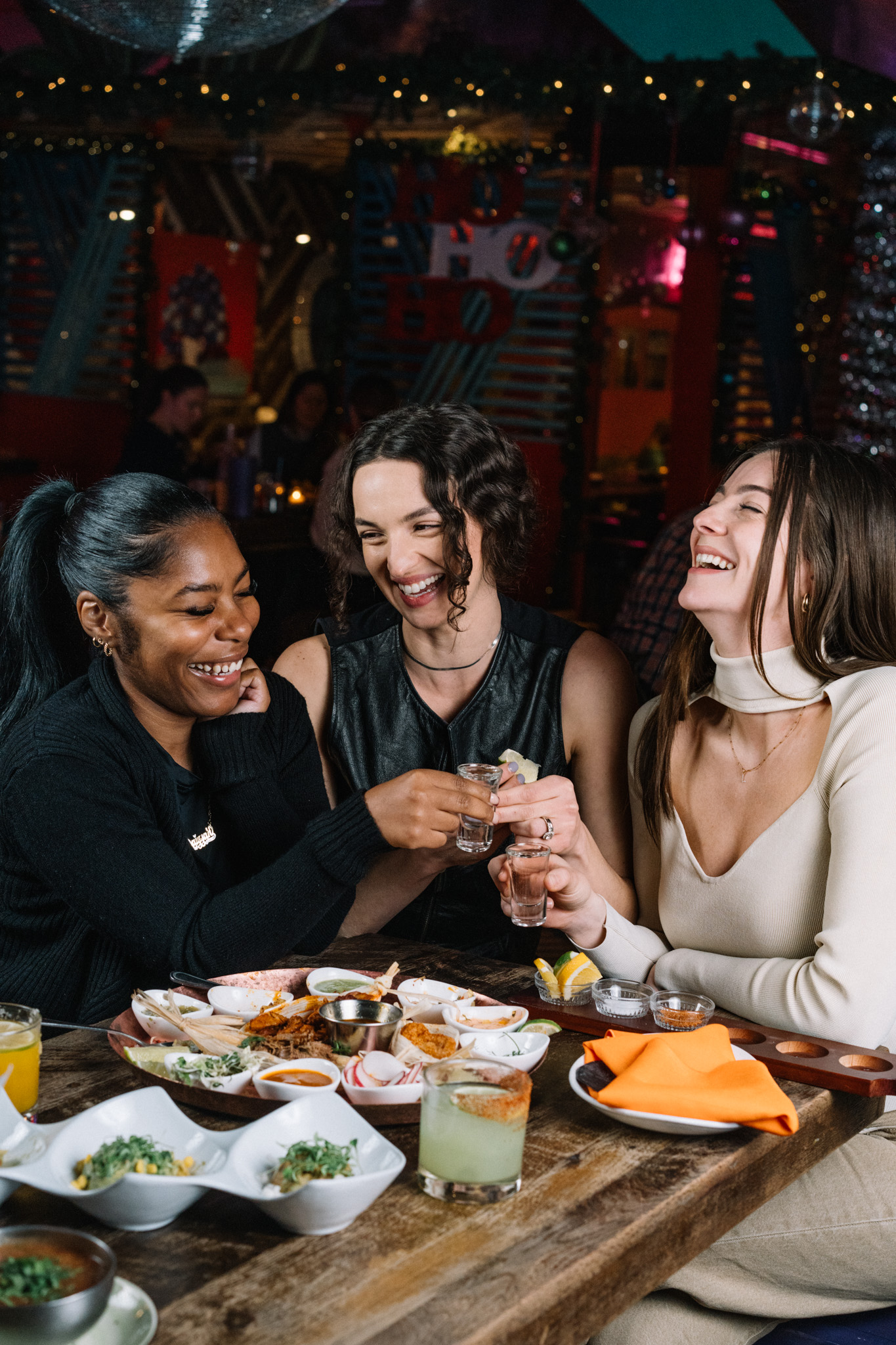 People at table drinking shots and eating food