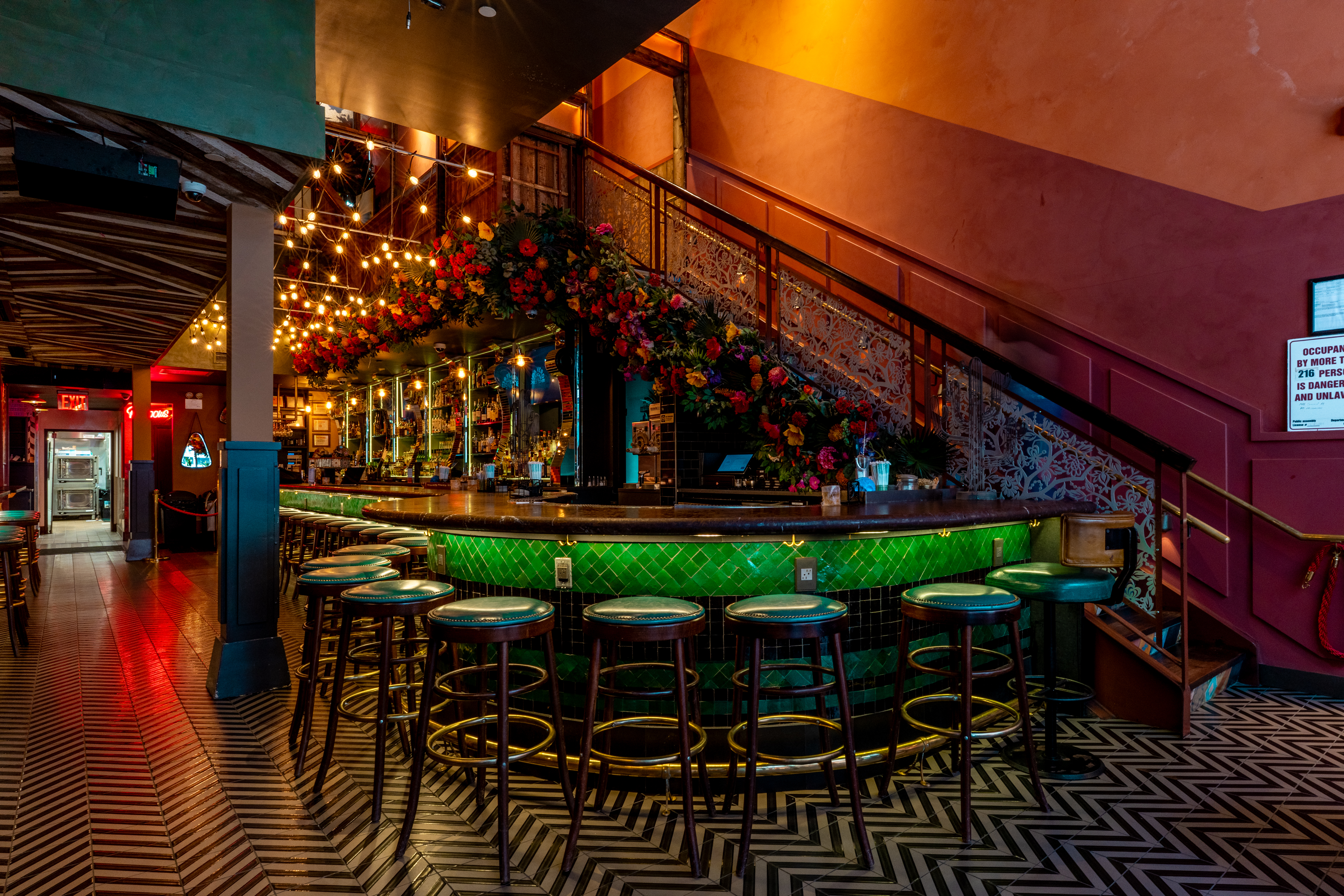 a bar with stools and a staircase