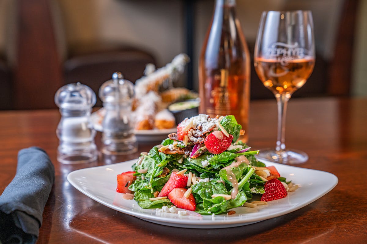 a plate of food and glasses of wine on a table