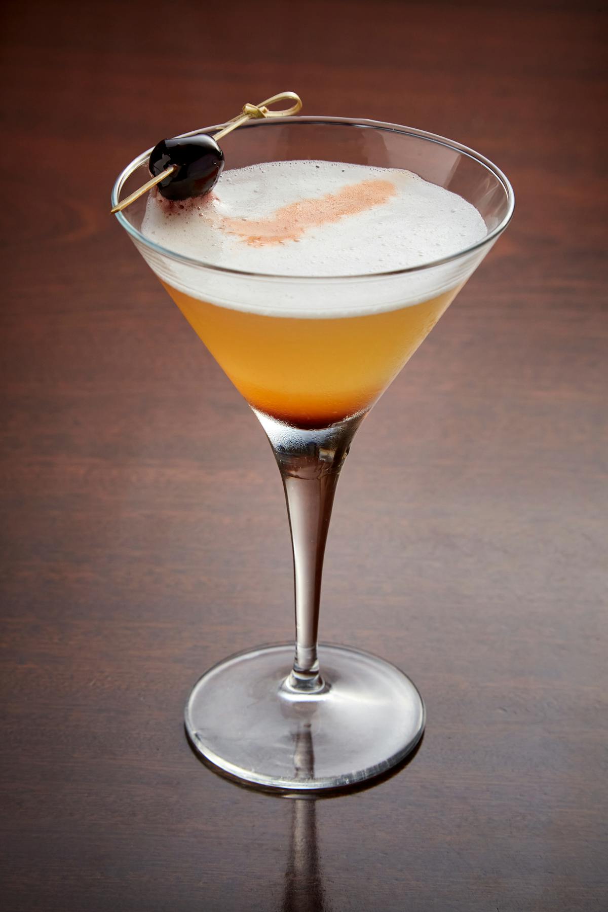 a glass of wine sitting on top of a wooden table