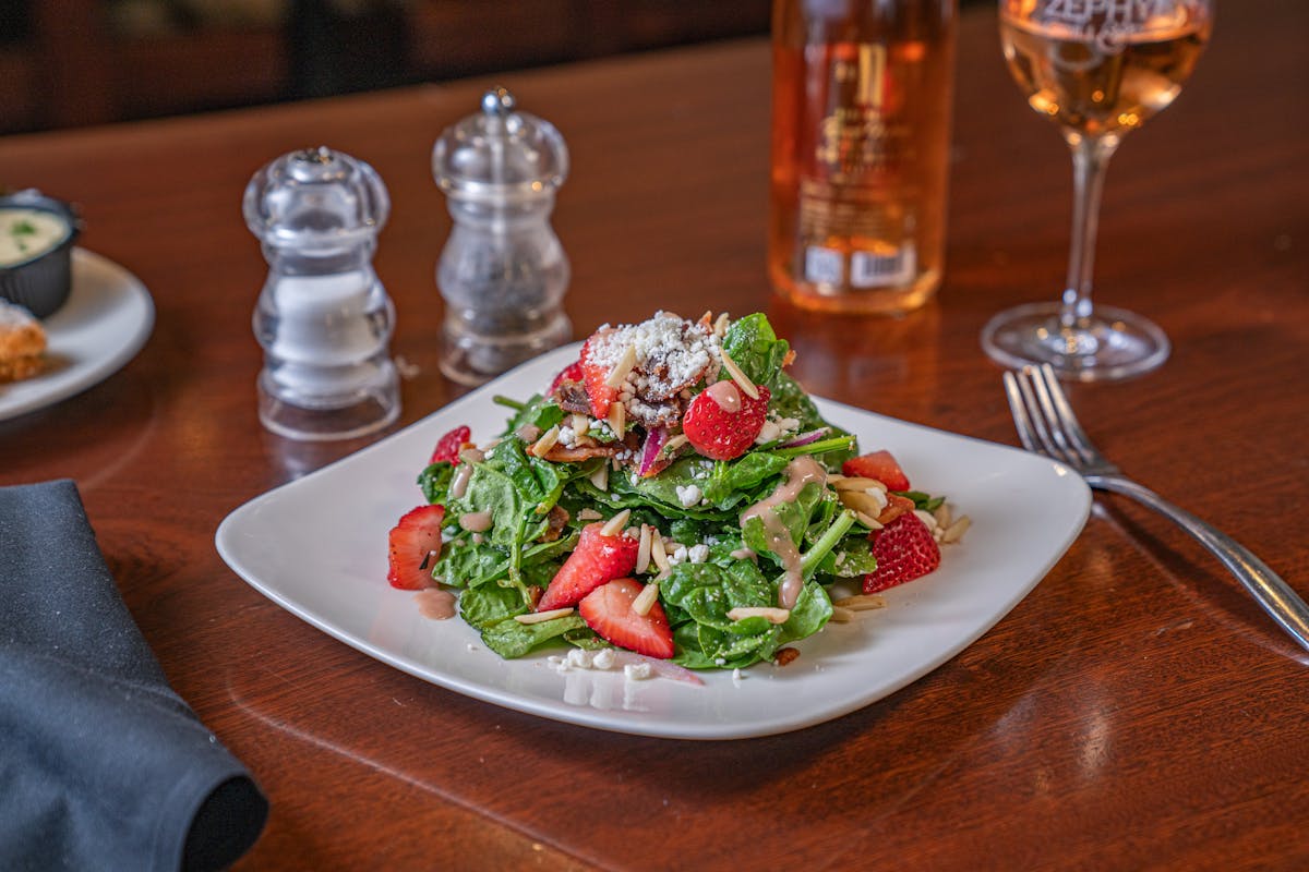 a plate of food and glasses of wine on a table