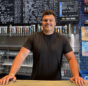 a man standing behind a bar
