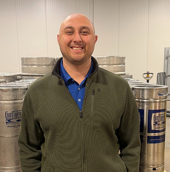 a man standing in front of kegs