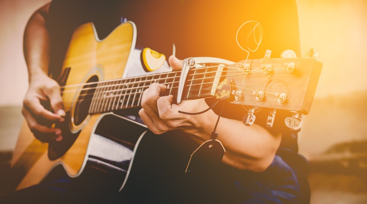 a hand holding a guitar