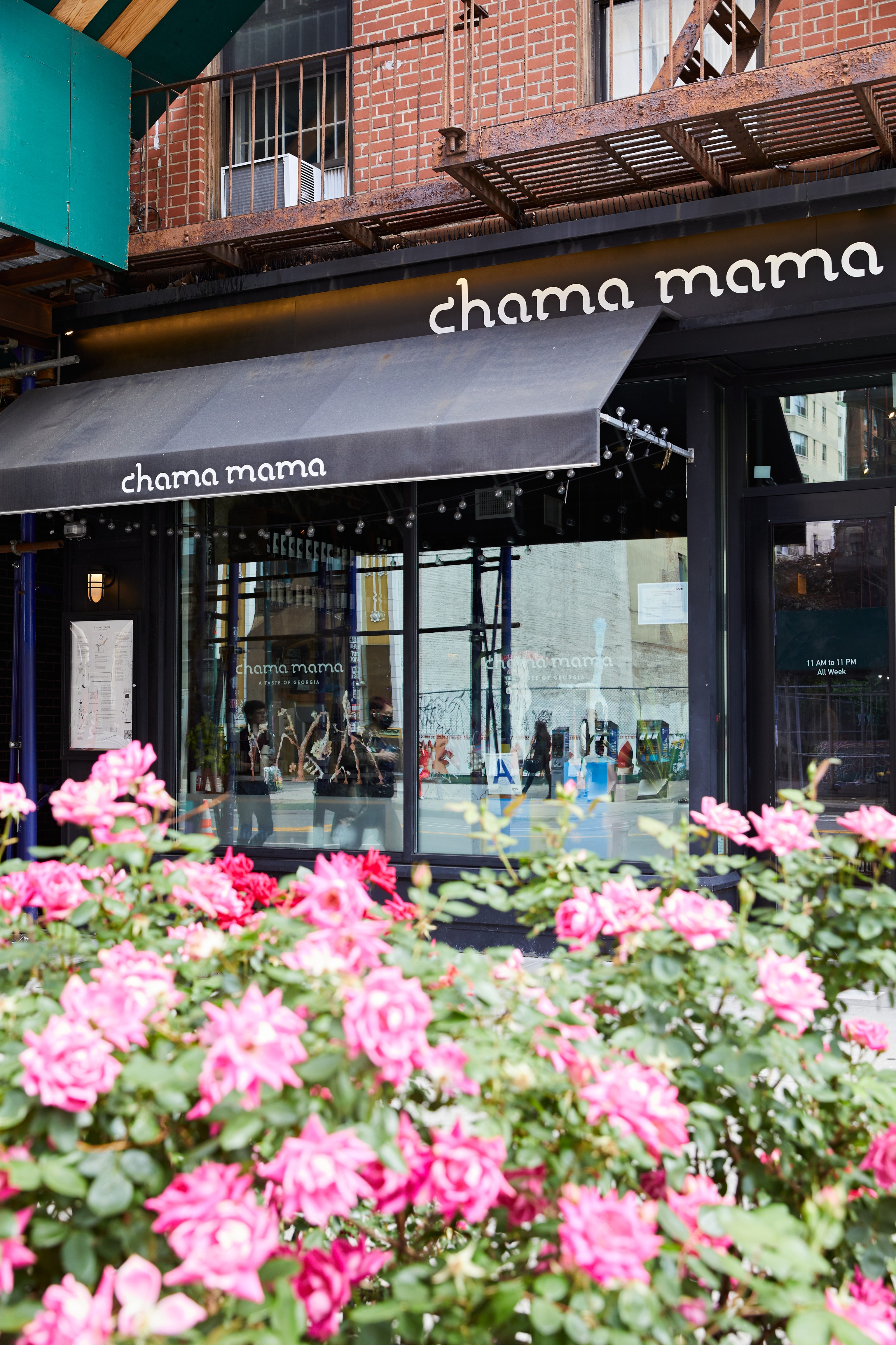 a pink flower is standing in front of a building