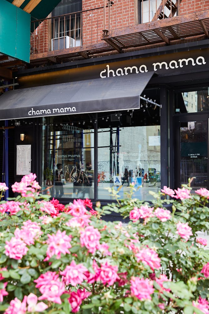 a pink flower is standing in front of a building