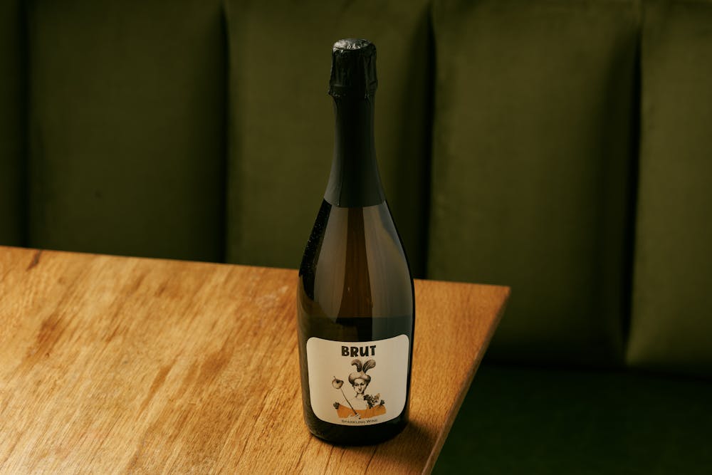 a bottle of wine sitting on top of a wooden table