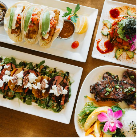 An image of four different dishes like tacos, steak, etc. on a table   