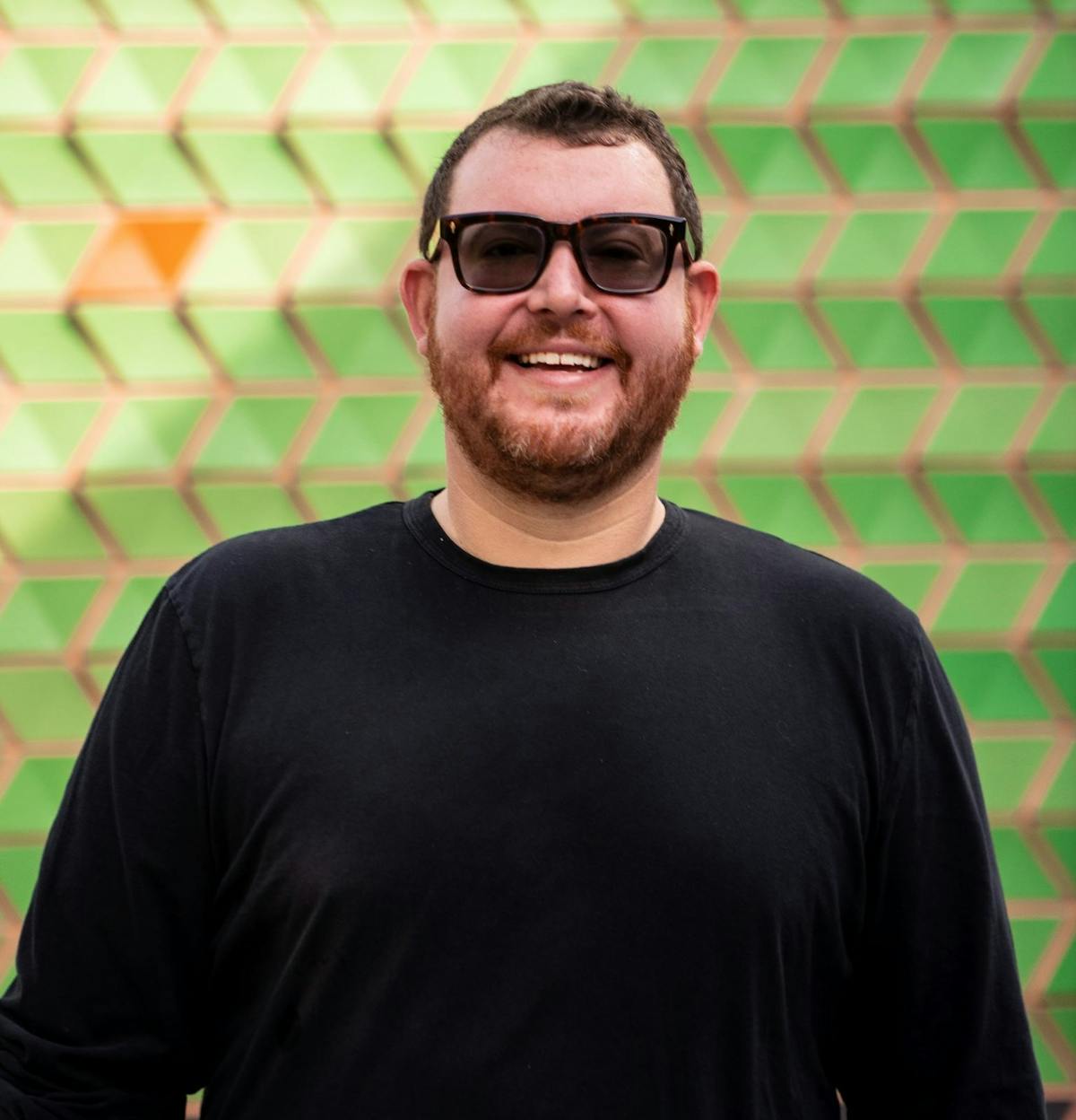 a man wearing glasses and smiling at the camera