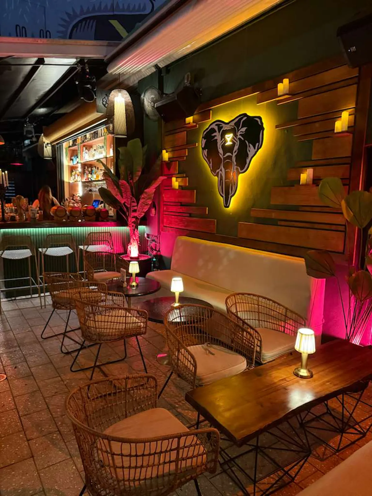 a room with a bar and a wall with chairs and tables