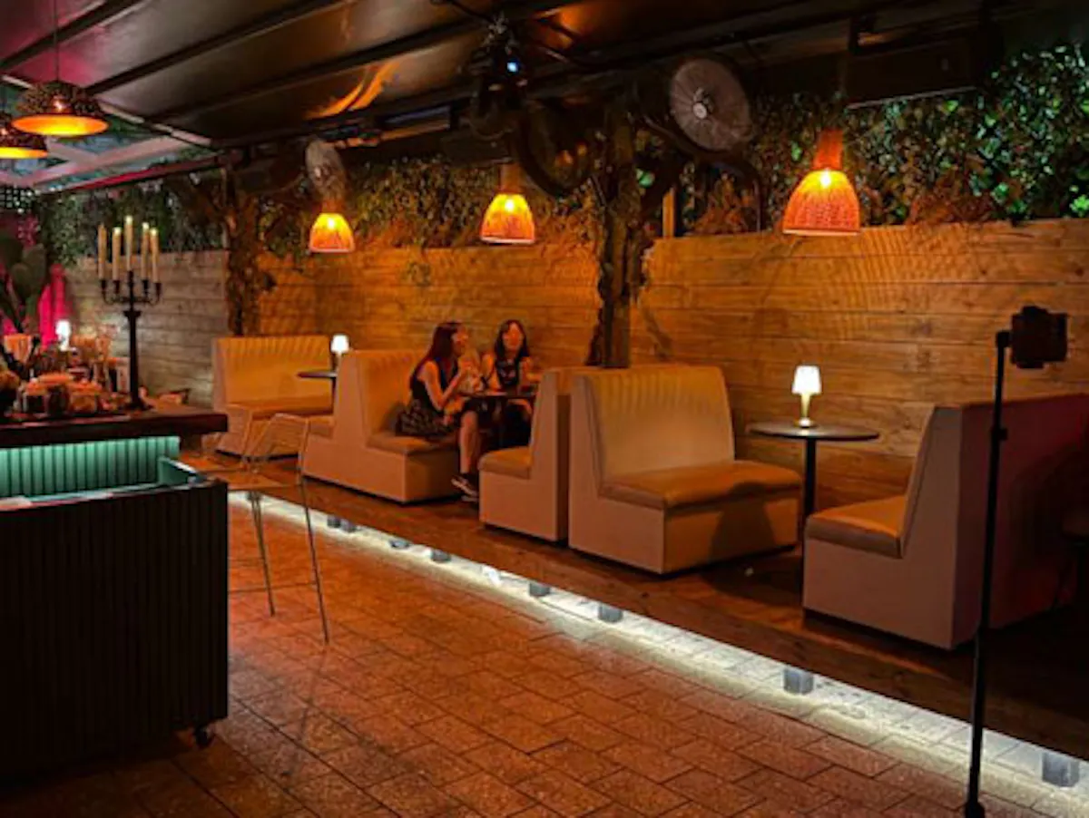 a room with a bar and a couple of people sitting on chairs
