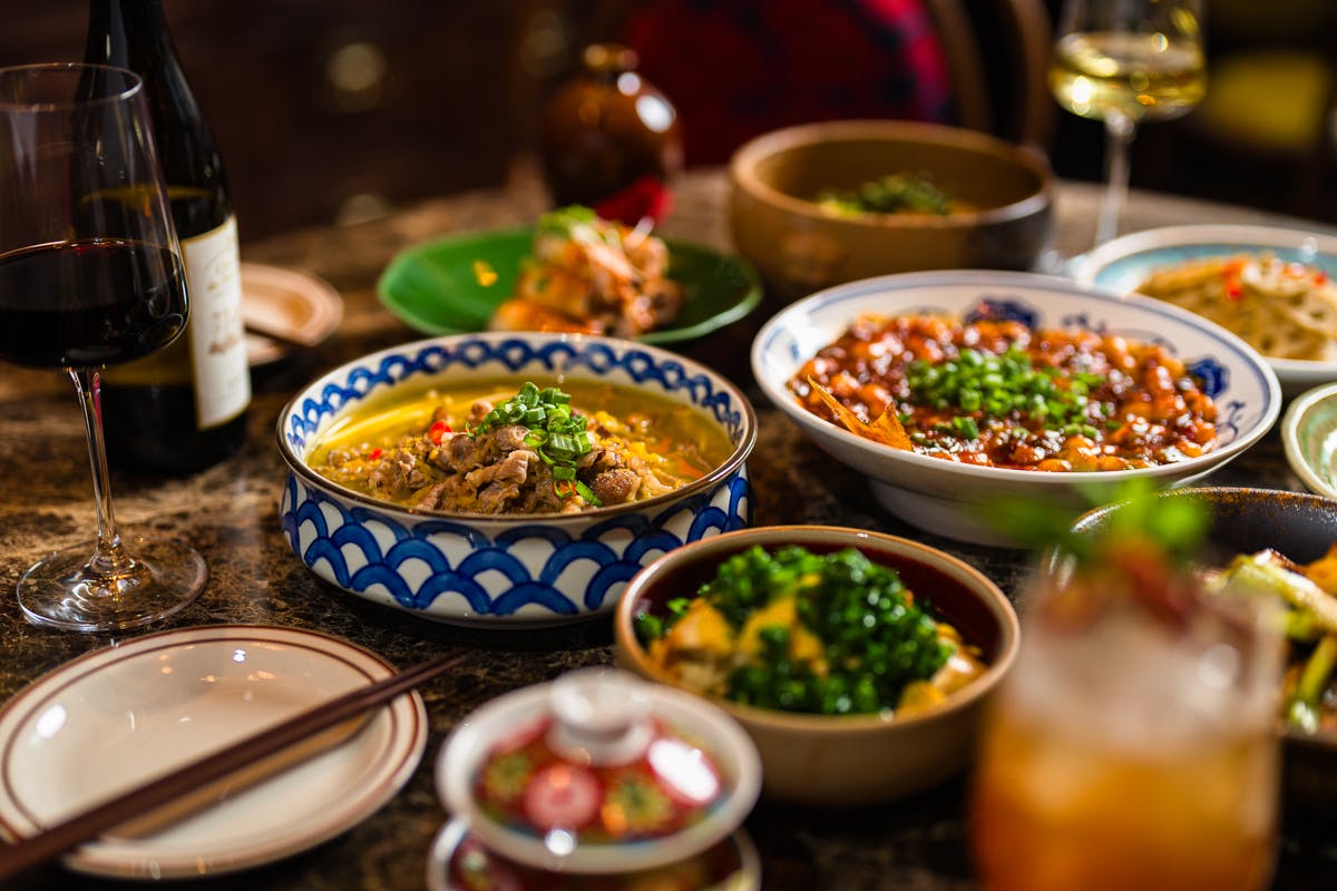 a bowl of food and glasses of wine on a table