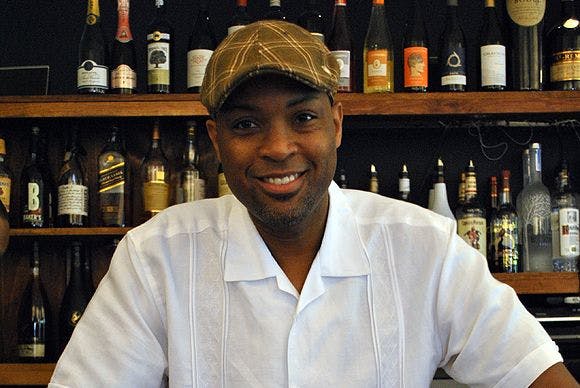 a man sitting at a table with wine glasses