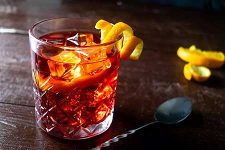 a negroni cocktail on a dark table