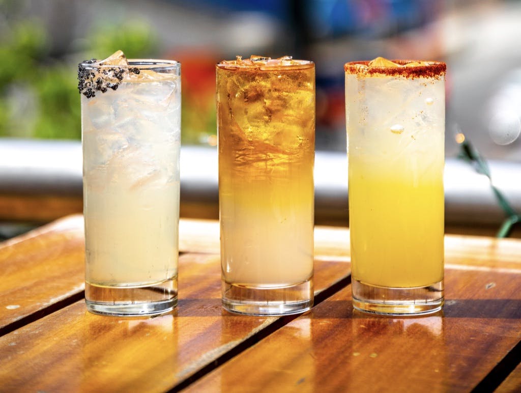 three glasses of juice on a table